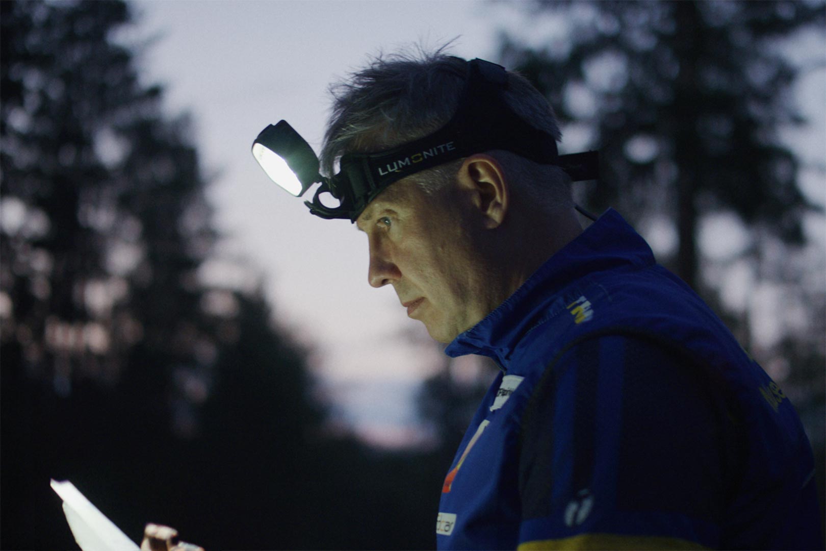 Suunnistaja yöllä metsässä. Pysäytyskuva, TV-mainos.